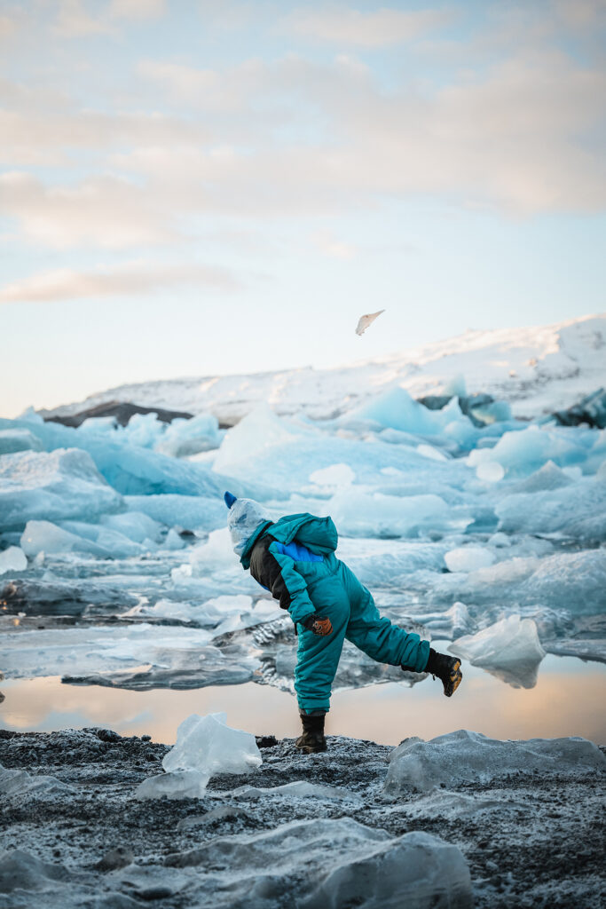 Child playing near icebergs in Iceland